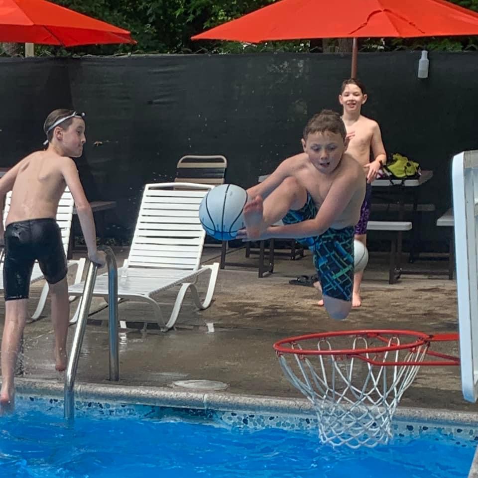 Luke dunking a basketball in the pool